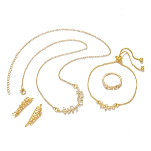 Detailed view of leaf-shaped gold jewelry set with sparkling white zircon stones