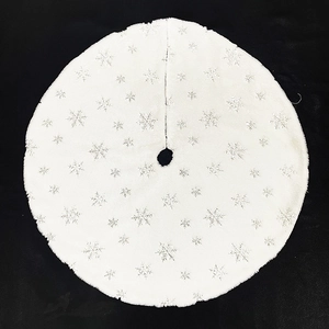 Detail of white faux fur Christmas tree skirt with shiny silver snowflake patterns