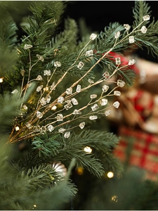 Detailed view of golden decorative branch with crystal ice accents on a Christmas tree