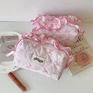 Detail view of pink floral quilted cosmetic bags with delicate ribbon lace trim