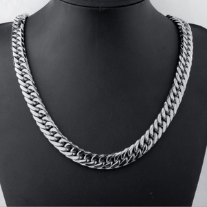 Close-up of silver stainless steel Cuban link chain on a black neck display stand