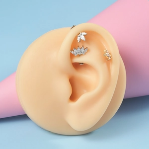 Detailed view of crown and leaf cartilage studs with marquise zircon on ear model