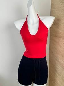 Detail of red halter neck crop top showing deep V-neck and slim fit tailoring