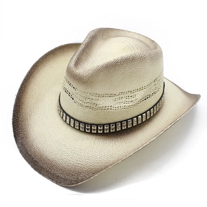 Détail d'un chapeau de cow-boy tissé avec bord dégradé, bande en cuir et clous