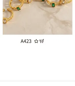 Detail of vintage stackable rings with gold rope texture and green square gemstones