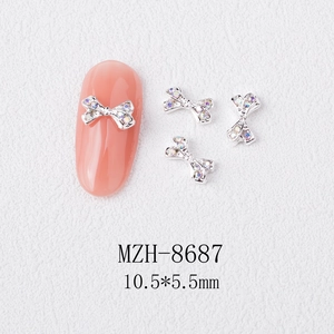 Detail view of silver bow nail art charm with colorful rhinestones, size 10.5x5.5mm