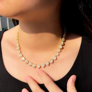 Close-up of golden Cuban chain featuring iced-out heart links with sparkling zircons