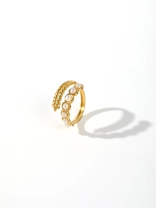 Detailed close-up of golden braided ring featuring a cluster of six white pearls