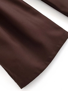 Dettaglio ravvicinato dei pantaloni marrone scuro con cuciture precise e trama del tessuto