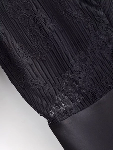 Close-up detail of premium black lace fabric with intricate floral embroidery patterns