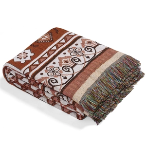 Detail of bohemian woven blanket with ethnic geometric patterns and colorful tassels