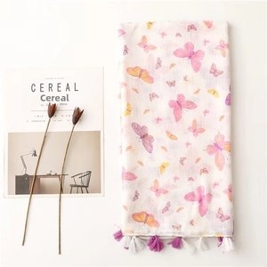 Detailed shot of white floral scarf with butterfly prints and purple tassel accents