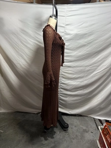 Brown long-sleeved knit dress with ruffles and V-neckline shown from a side view