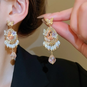 Detail of vintage gold earrings with champagne crystal drops and bead tassels