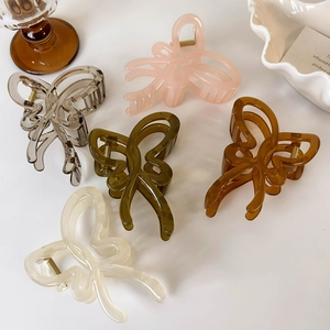 Close-up of translucent butterfly hair claws in five pastel colors on a white tray