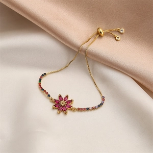 Detailed macro view of gold flower bracelet featuring red gems and colorful crystals