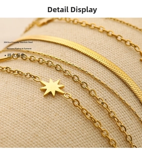 Detail of 18K gold-plated stainless steel snake and cross chains showing texture