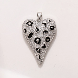 Macro shot of silver heart pendant with leopard pattern enamel and sparkling zircons