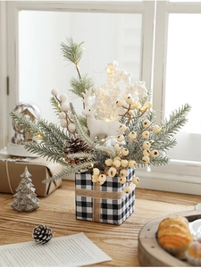 Close-up of Christmas box with flocked deer, pine branches, cones and warm LED lights