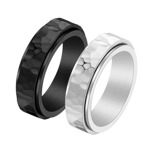 Detail of silver and black hammered texture stainless steel rotating rings for men