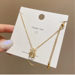 Detailed macro of gold plated crown necklace with a shimmering white cubic zirconia stone