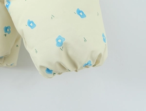 Close-up of floral print on beige winter jacket with elasticated cuff details