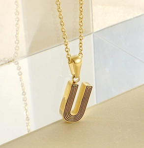 Détail du collier pendentif lettre U plaqué or 18k avec lignes noires sur chaîne fine