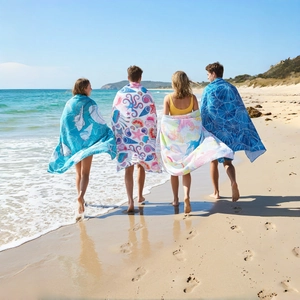 Microfiber beach towels with marine patterns shown by models on a sunny beach