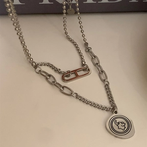 Détail du collier argenté double épaisseur avec pendentif éléphant et maillons en H