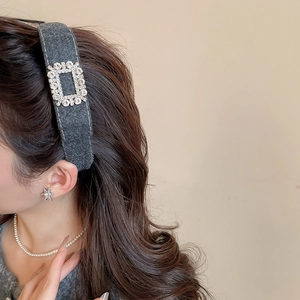 Close-up of grey velvet headband with rectangle rhinestone buckle on model side view