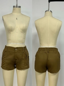 Detail view of high waist cargo shorts with elastic waistband and side flap pockets
