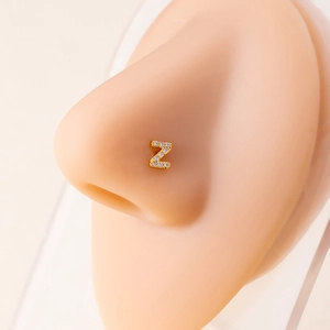 Detailed macro view of a gold nose stud featuring a micro-set zircon letter Z