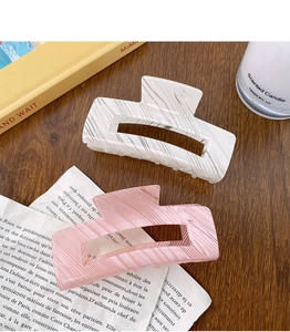 Detail of vintage cream striped hair claws in pink and white marble on a cozy desk