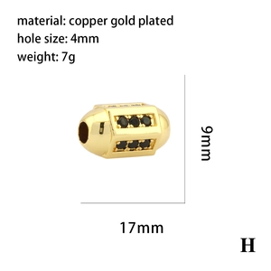 Détail macro d'une perle cylindrique en cuivre plaqué or 17mm avec zircons noirs