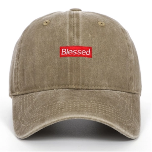 Close-up of Blessed red embroidery patch on vintage washed khaki baseball cap fabric