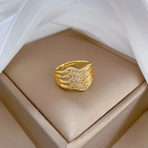 Macro detail of four-layer gold-plated wave ring with micro-set white zircon stones