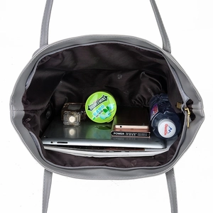 Grey soft leather tote bag showing large capacity interior with various items