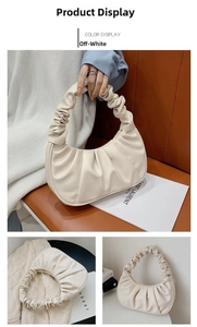 Dettaglio della borsa a spalla bianco crema con design increspato e trama in pelle