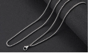 Polished silver stainless steel square pearl link chain with lobster clasp on black background