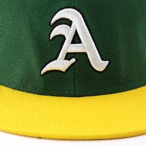 Detailed view of 3D embroidered white letter A on a green and yellow flat brim hip-hop cap
