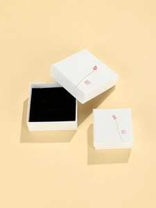 Macro view of white square jewelry box with lotus bud print and black velvet insert