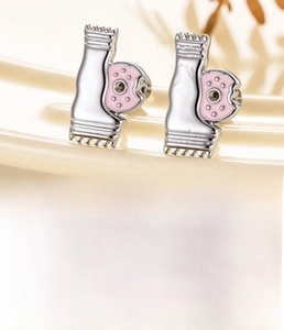 Vue macro d'une boucle d'oreille en acier titane avec motif de beignet rose