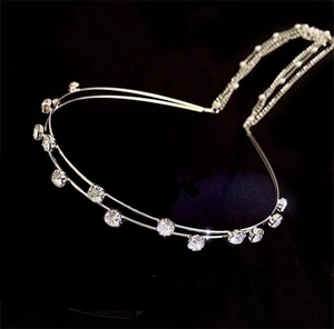 Macro shot of double-row silver headband with sparkling clear crystals on black background