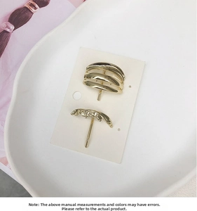 Detail view of golden minimalist hollow ponytail clips and wavy metal hairpins on display