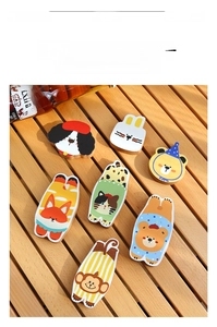 Detail of wooden cartoon animal bottle openers with magnetic back on light wood surface