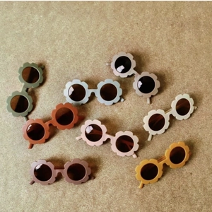 Flat lay of flower shaped matte kids sunglasses in eight trendy Morandi colors