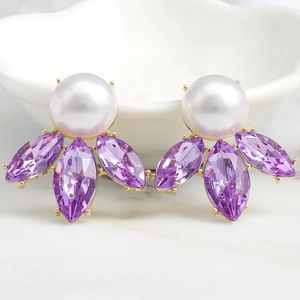 Close-up of luxury gold earrings with white pearls and purple marquise crystals