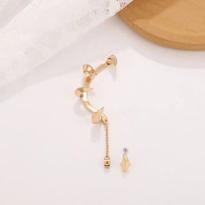 Detailed view of golden thorn claw ear cuff with chain and drop stud in punk style