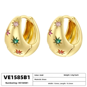 Detailed close-up of gold brass hoop earrings with multi-colored star zircon inlays