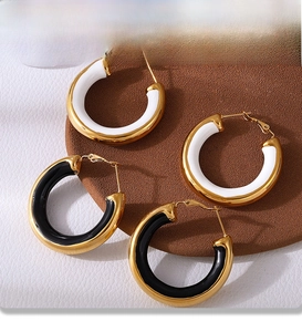 Detail of PVD electroplated gold hoop earrings with black and white enamel insets